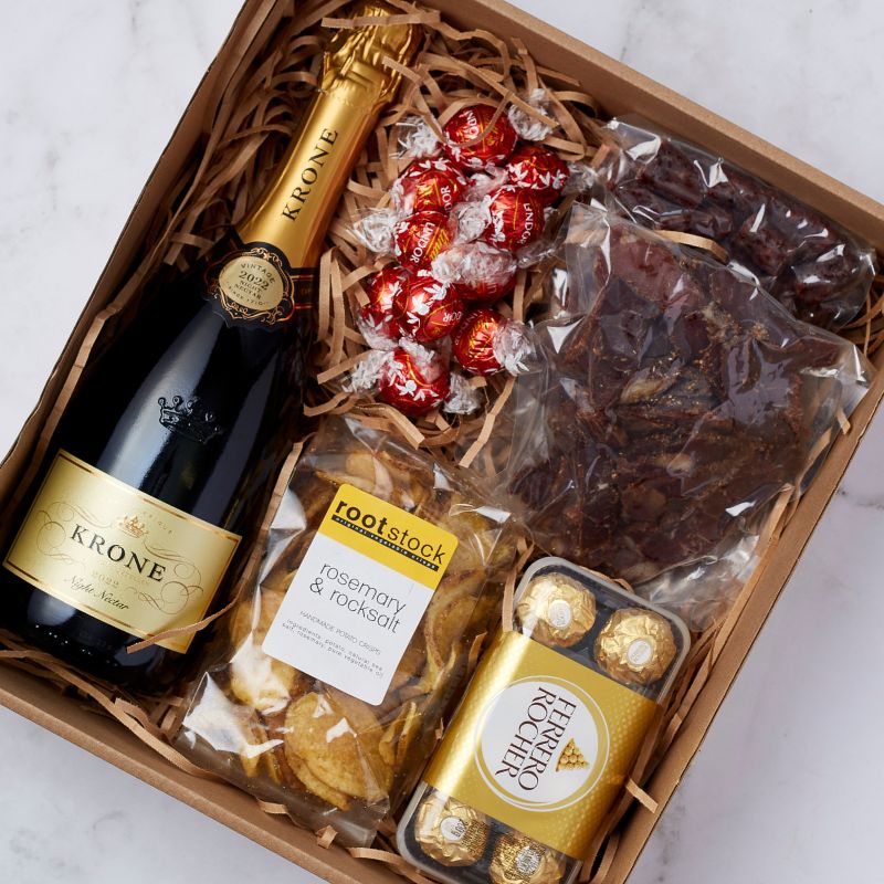 Luxury gift set featuring Krone sparkling wine, Lindor chocolates, biltong, rosemary crisps, and Ferrero Rocher chocolates.