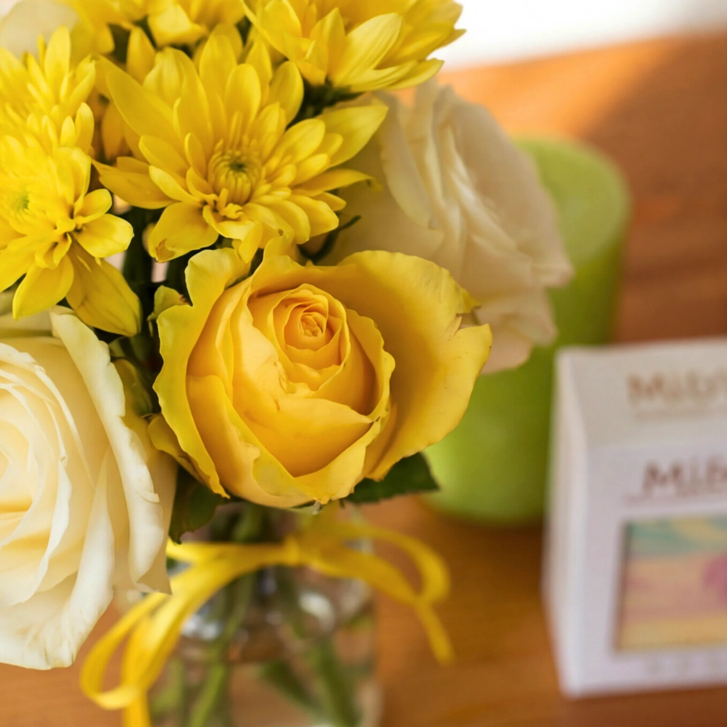 Close-up of the yellow and cream rose posy in the Lather & Light candle gift set, beside the soap and candle