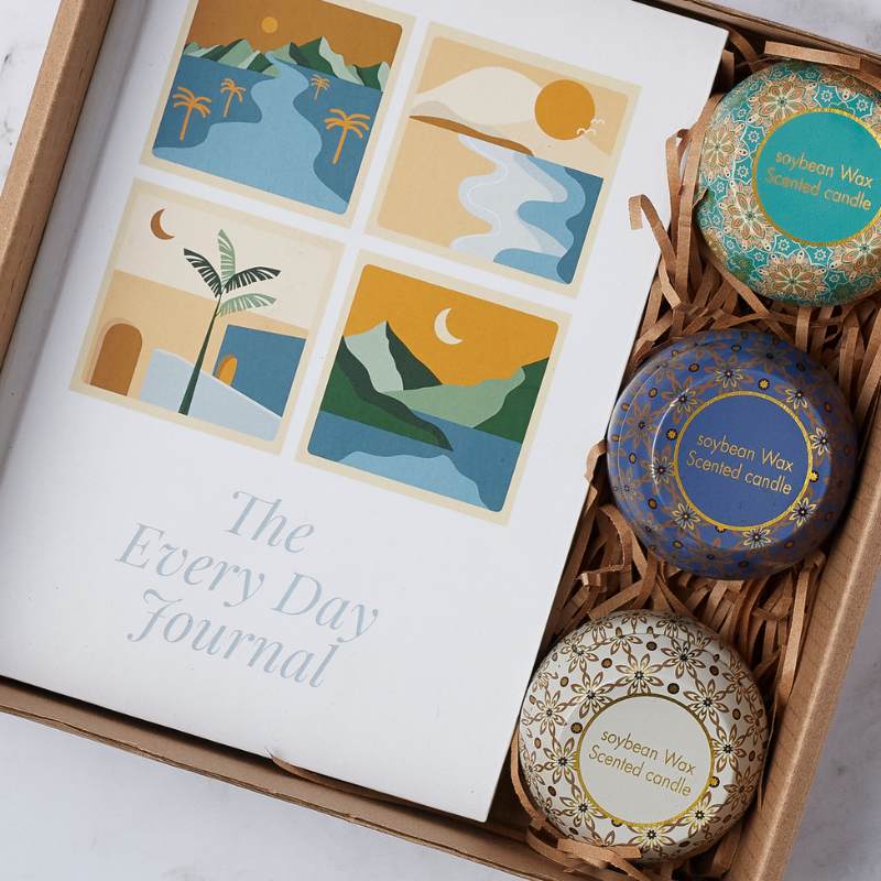 Close-up of the Loving Nurture Gift Set featuring The Every Day Journal and three artisan soybean wax candles in vibrant patterned tins.