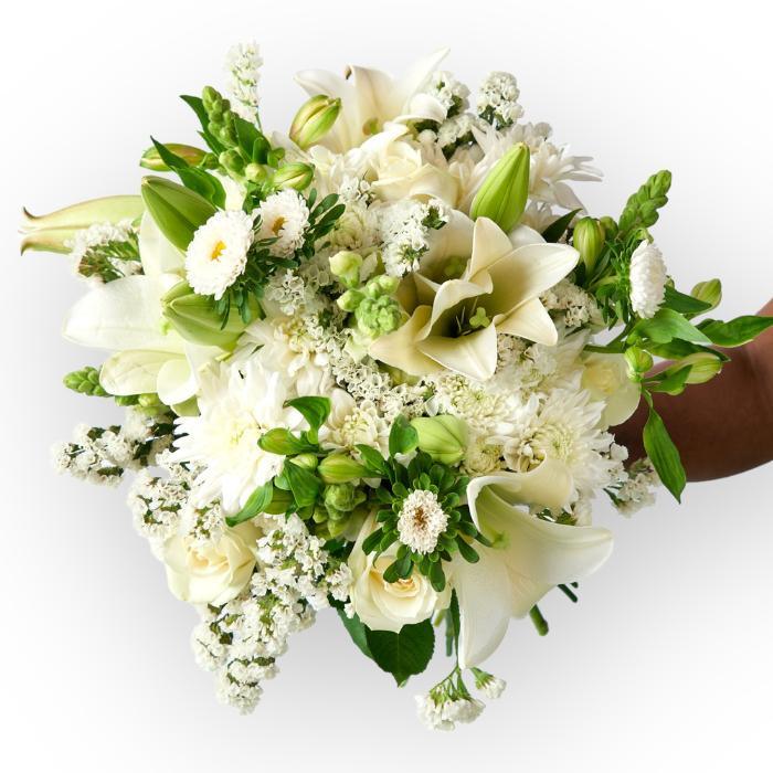 Bouquet of white and green flowers held by a hand on a white background