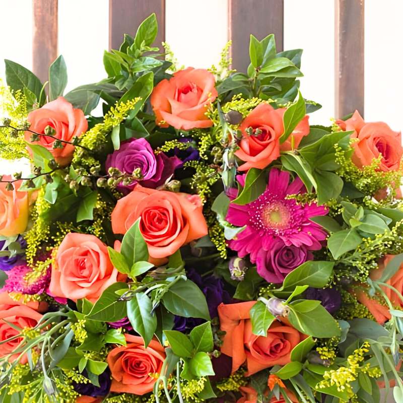 Colourful flower bouquet with roses and gerberas in a wooden box.