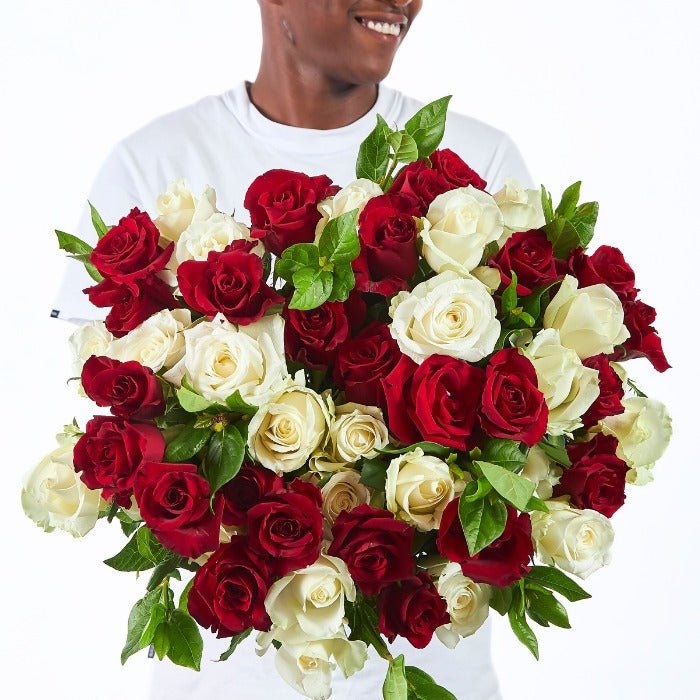 Elegant rose bouquet featuring approx. 50 red and white roses with lush greenery, perfect for romantic gifting.