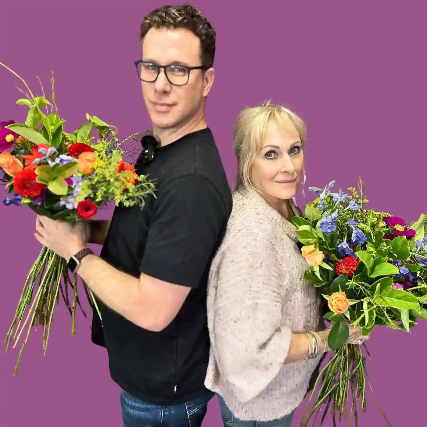Fabulous Flowers and Gifts owners Nicholas James and Josie van Aswegen standing back to back, each holding vibrant bouquets. Fabulous Flowers and Gifts.