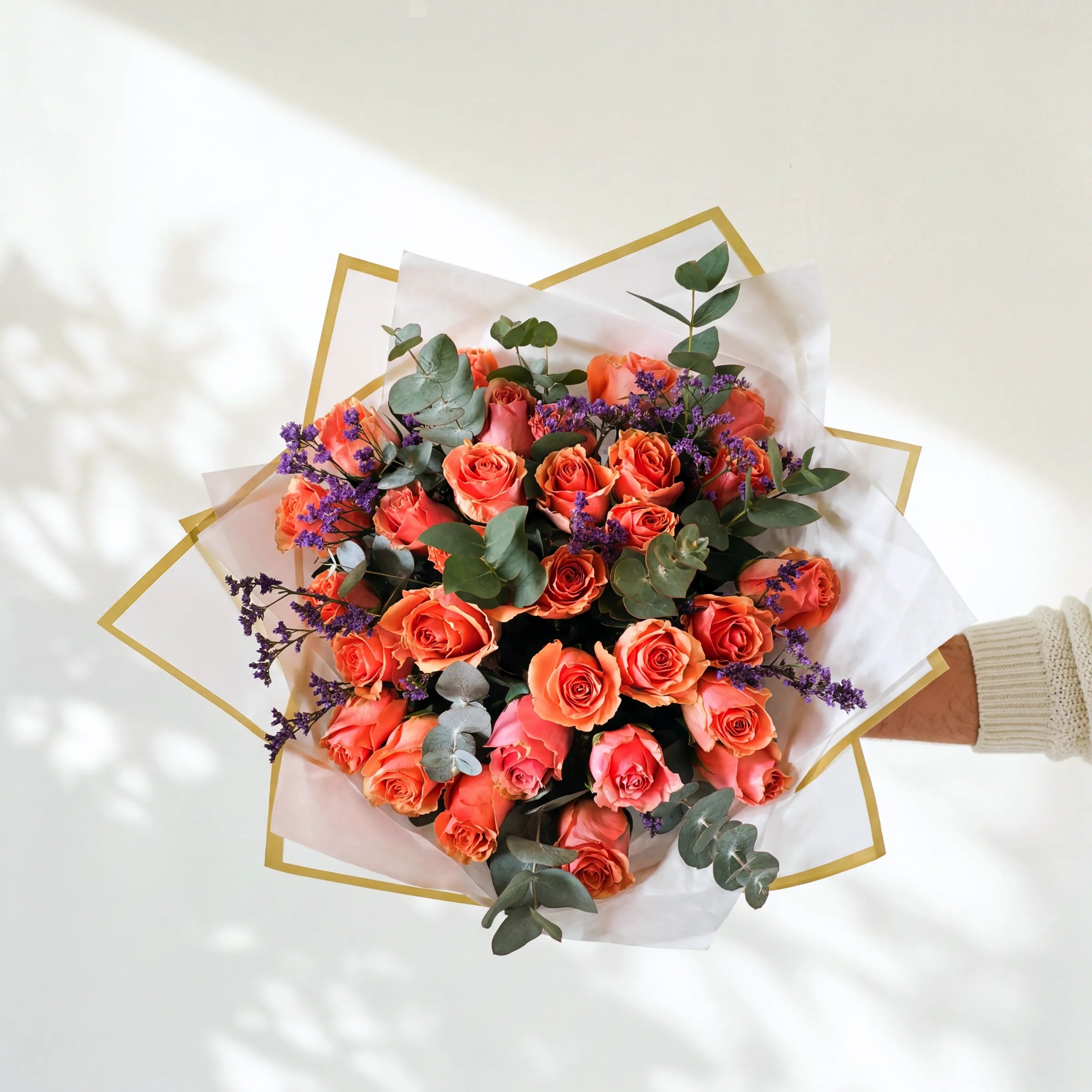 Large Orange Royale, a full top-down armful of coral-orange roses, eucalyptus and purple limonium by Fabulous Flowers