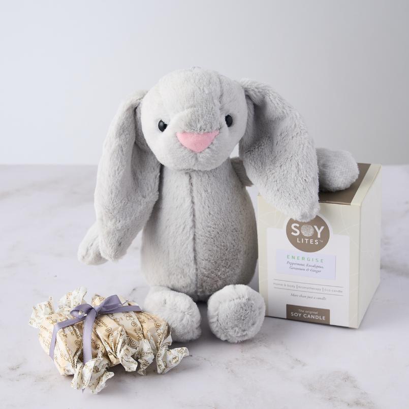 Pamper Bunny for Baby Boy Gift Set with a grey plush bunny, Soy Lites Energise candle, and Sally Williams nougat, arranged on a white surface.
