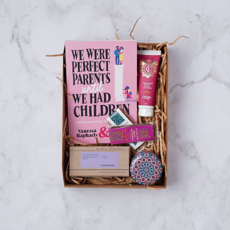 Parent's Pause Gift Box with a parenting book, hand cream, artisanal chocolate, soy wax melts, and a decorative candle.