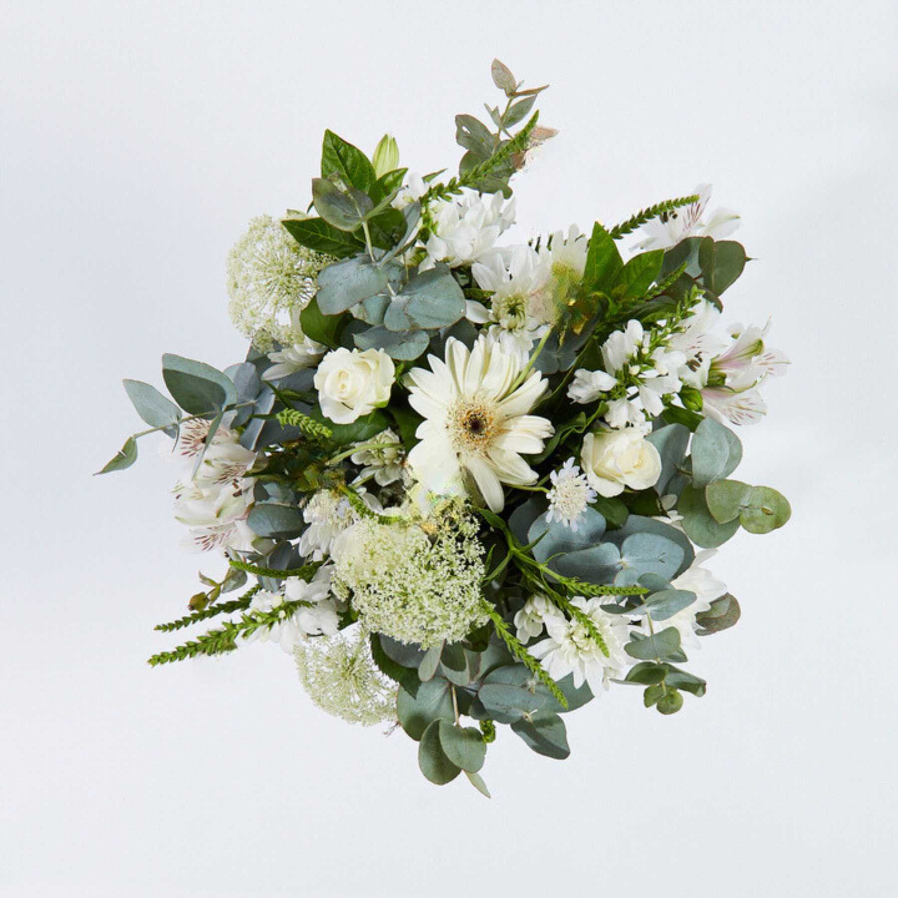 Top view of a lush white floral bouquet with a variety of blooms and greenery