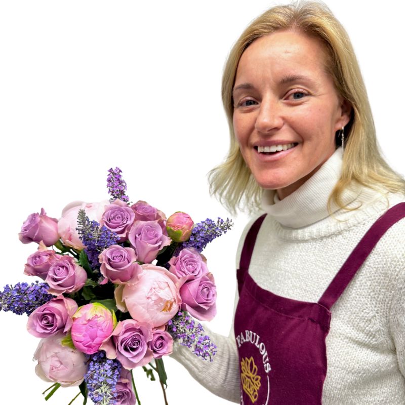 Smiling florist with Peonies at Dusk bouquet in purple tones and soft peonies – Fabulous Flowers and Gifts.