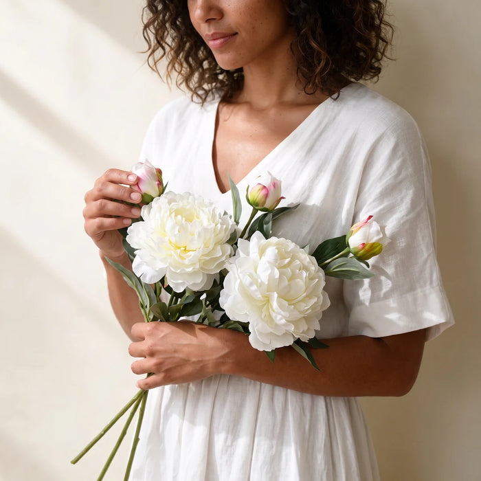 Woman holding three white peony artificial flowers from Fabulous Flowers