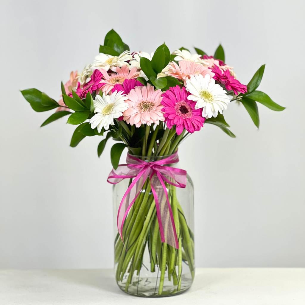 Pink-a-Boo Gerbera Blossom Arrangement next to Pomegranate and Vanilla Bath Crystals. 30 Mixed pink and white gerbera daisies - Fabulous Flowers