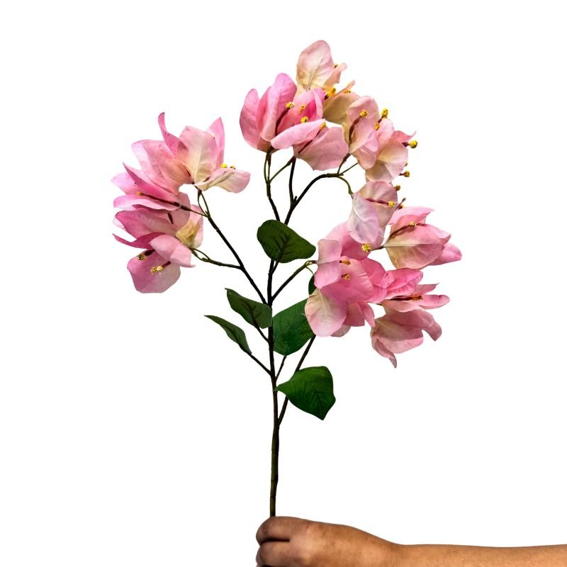 Artificial pink flower branch held by a hand on a white background