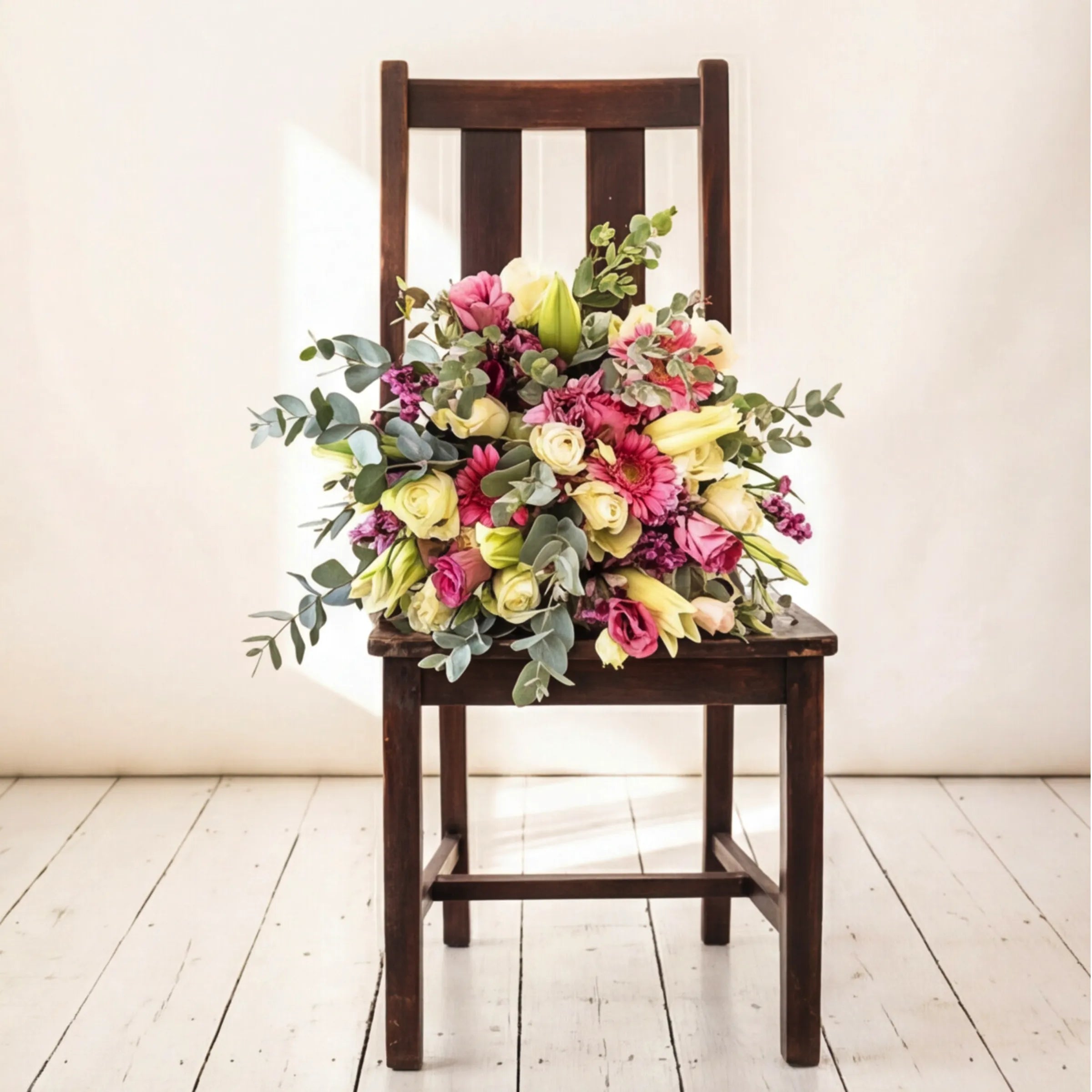 Pink Expression Bouquet held in arms showing pastel pink and white roses, pink lisianthus and eucalyptus hand-tied in kraft wrap, locally grown by Fabulous Flowers South Africa