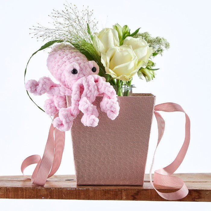Pink Puddle Octopus Garden: Handmade pink octopus plush toy surrounded by white floral arrangement in gift packaging.