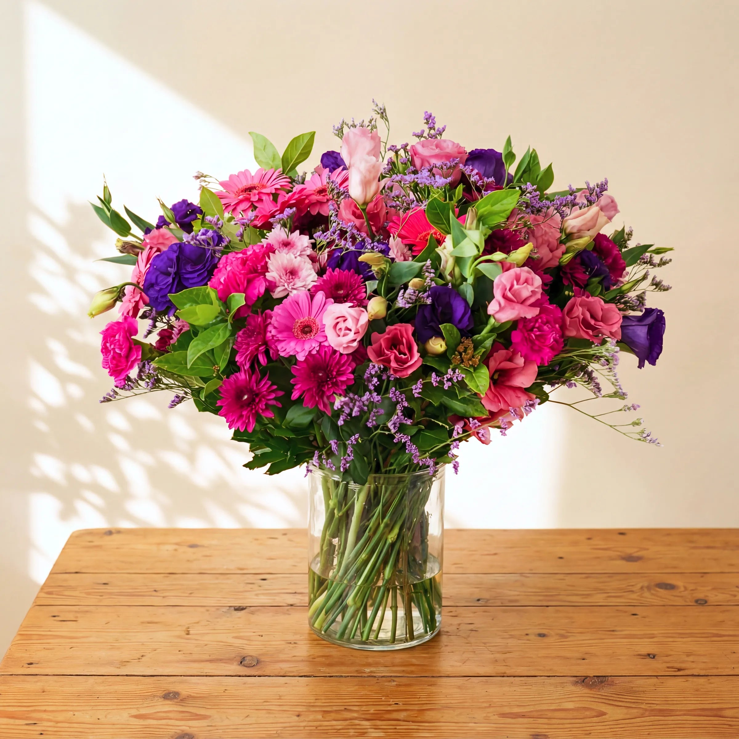 Pretty in Pink and Purple vase arrangement with pink roses, gerbera, purple lisianthus, hot pink carnations and statice by Fabulous Flowers