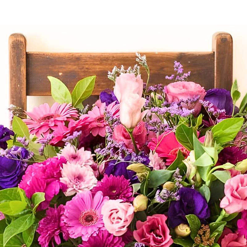 Colorful arrangement of flowers on a wooden chair