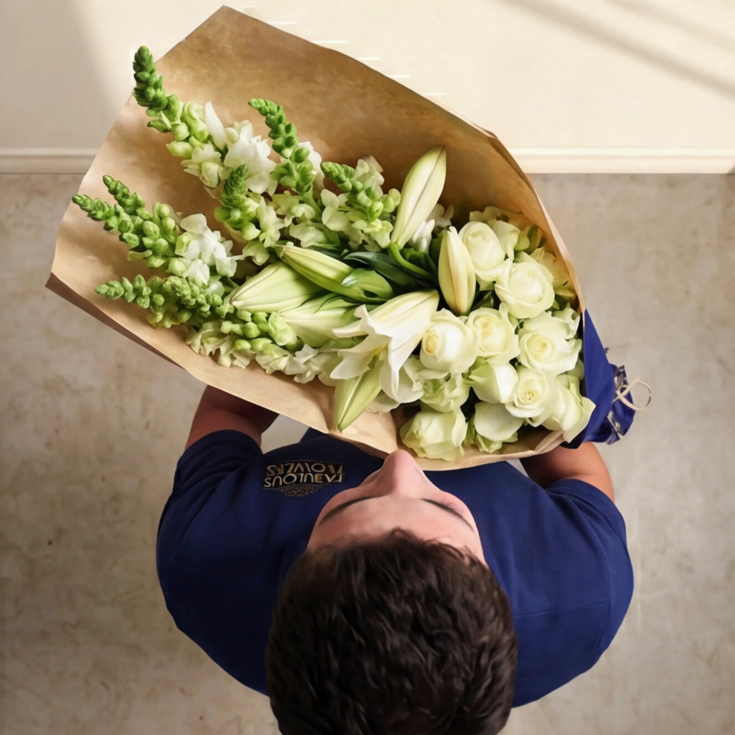 Overhead view of the Elegant White Bouquet, white roses, lilies and snapdragons, hand-tied by Fabulous Flowers