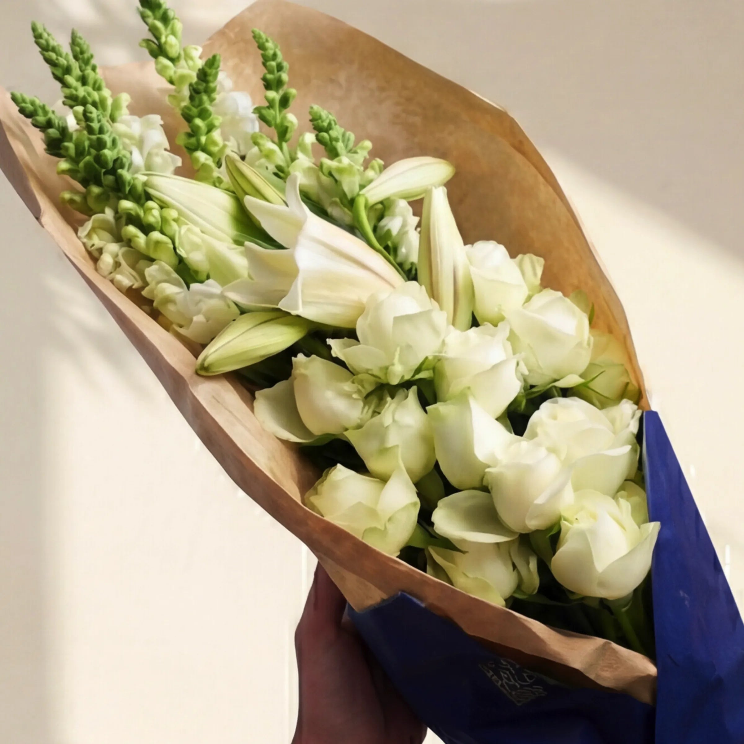 Elegant White Bouquet wrapped in kraft and navy, white roses, lilies and snapdragons, same-day Cape Town delivery