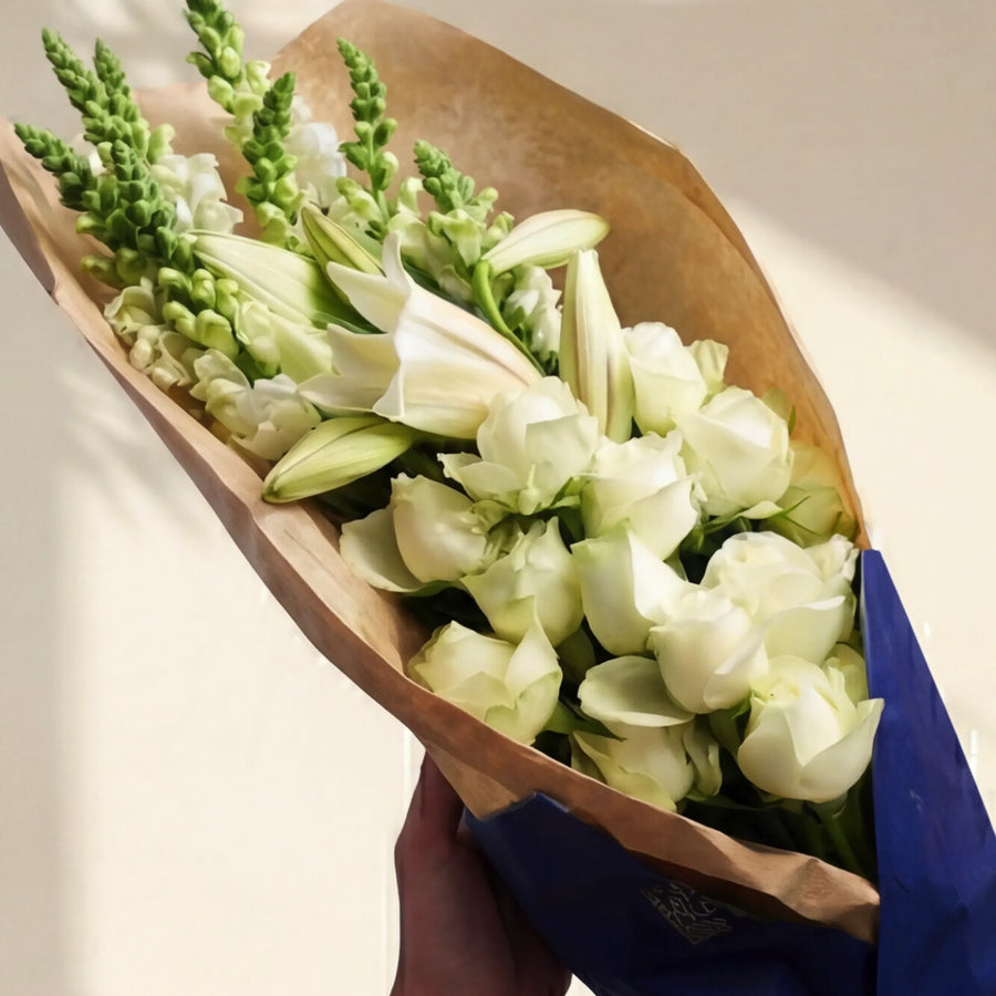 Elegant White Bouquet wrapped in kraft and navy, white roses, lilies and snapdragons, same-day Cape Town delivery