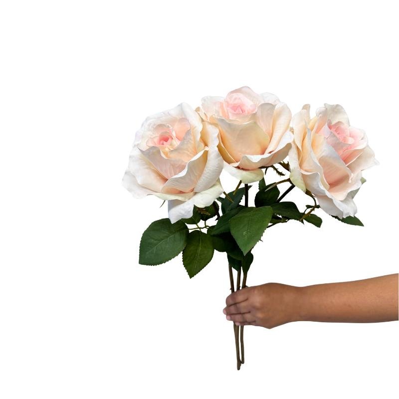 Bouquet of white and pink roses held by a hand on a white background