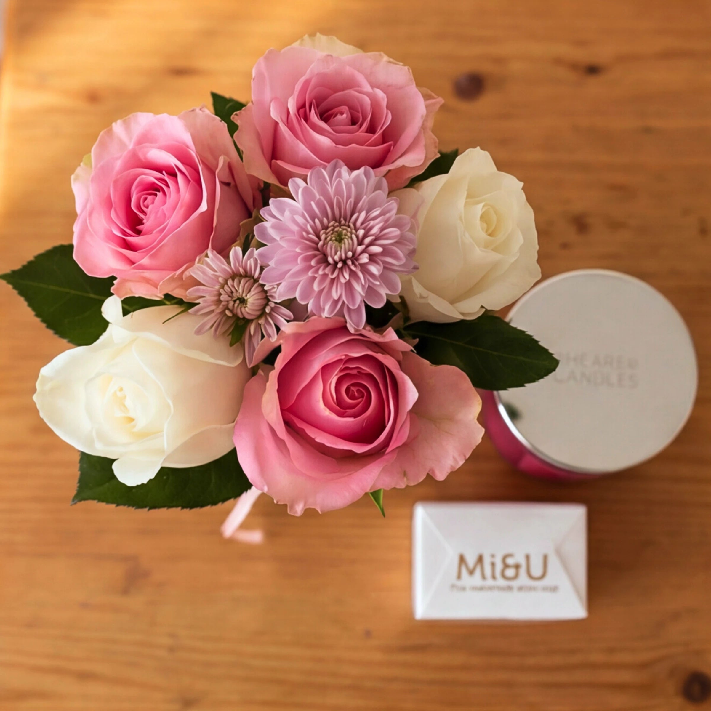 Top-down view of the Rose & Ember set, pink and cream roses, Mi&U soap and a Shearer candle