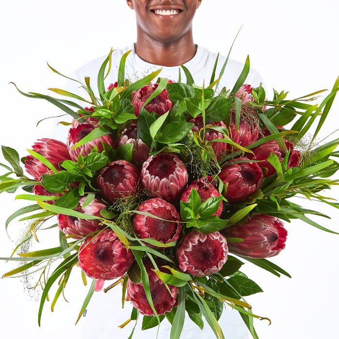 Royal Protea Flower Bouquet – bold pink Proteas and textured green foliage in a vibrant, hand-held bouquet