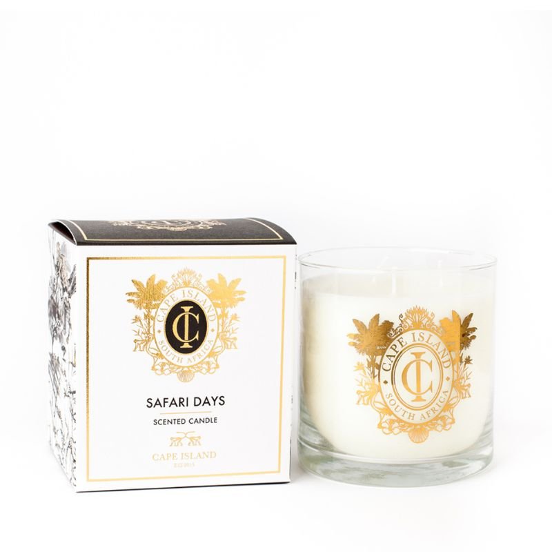 Cape Island “Safari Days” scented candle with white wax in clear glass and gold crest, shown beside its closed white-and-gold gift box.