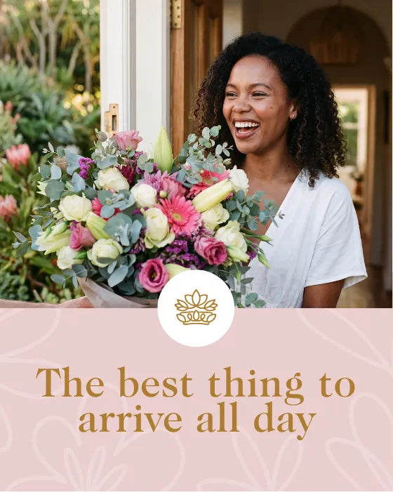 Smiling woman receiving a pink and white flower bouquet at her Cape Town front door