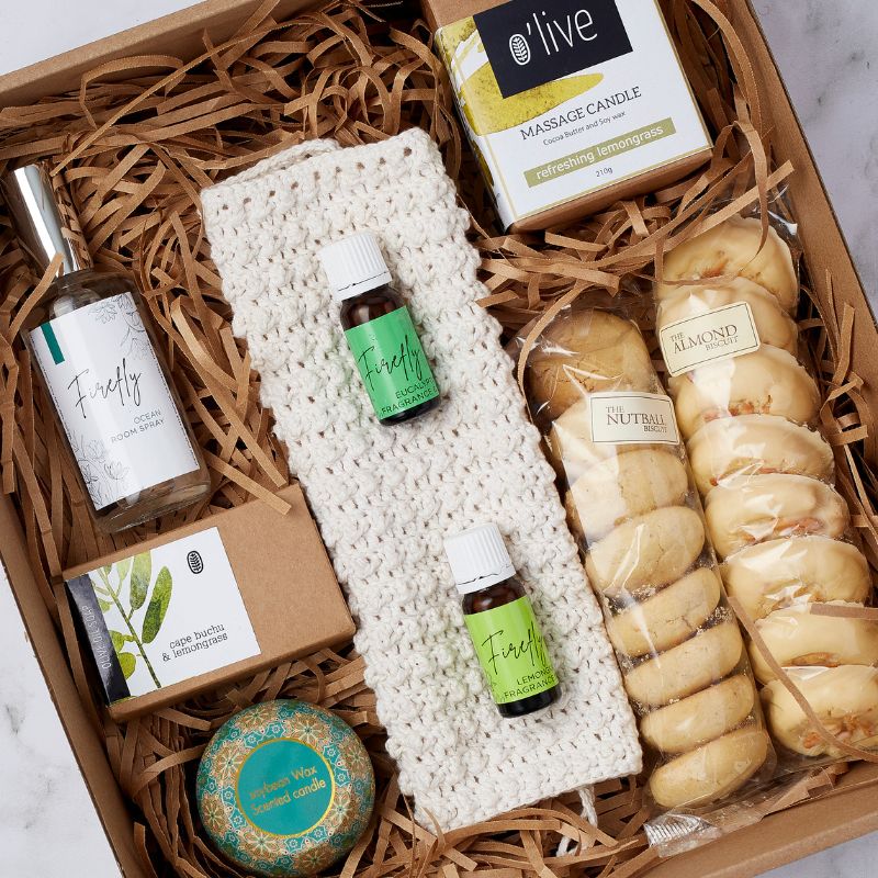 Gift box featuring Firefly ocean room spray, handmade crochet cloth, O'live massage candle, essential oils, and almond biscuits.
