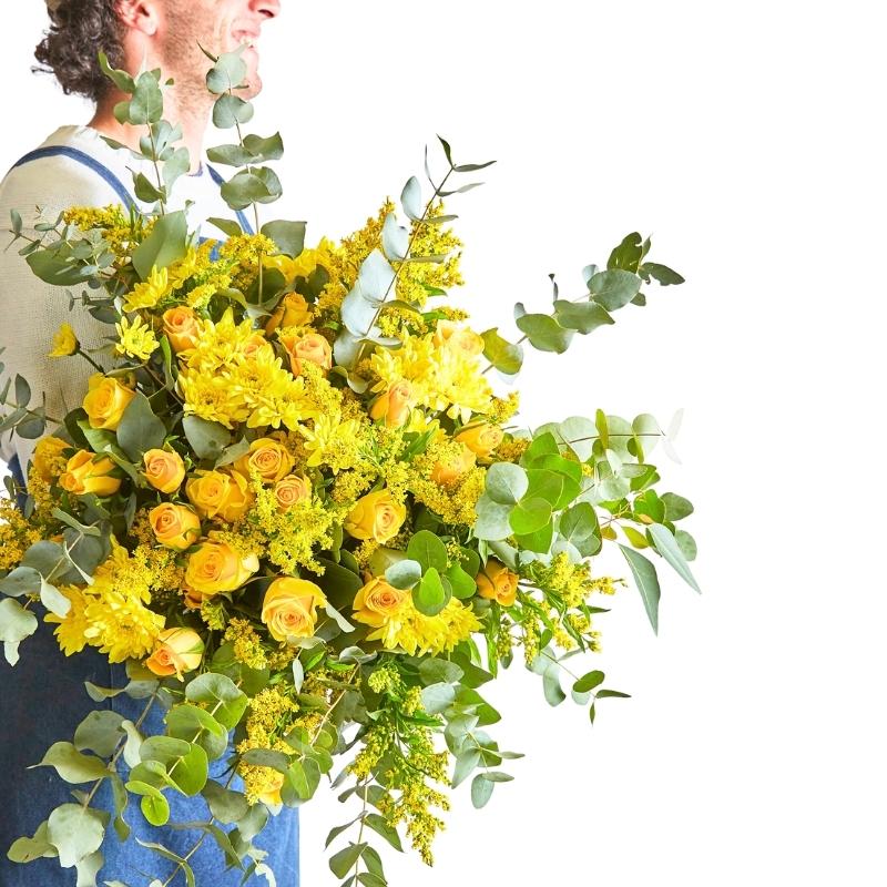 Sunkissed Yellow Bouquet held in arms—sunny yellow blooms and lush greenery, wrapped for gifting