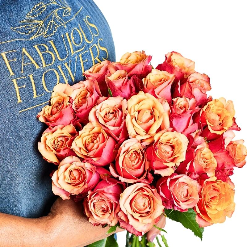 Close-up Sunset Rose Bunch with vibrant orange roses in tangerine and apricot shades, finished with greenery