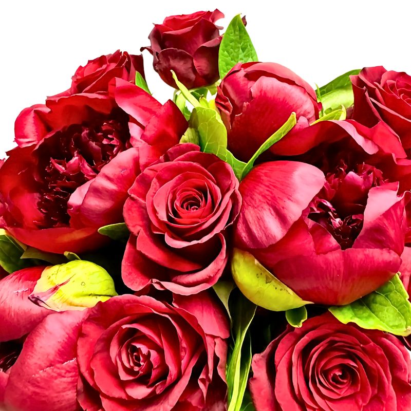 Close-up of The Bloom Between Us bouquet showing red roses and peonies with green foliage at Fabulous Flowers and Gifts.