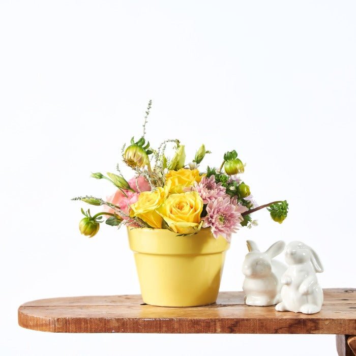 The Garden of First Light - Fabulous Flowers & Gifts yellow pot arrangement with pastel flowers and ceramic bunnies for Easter.