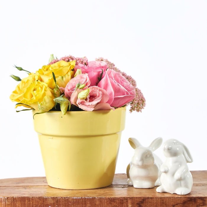 The Garden of Gentle Love - Fabulous Flowers & Gifts close-up of rose and lisianthus arrangement with white bunny figurines.