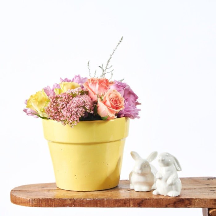 The Garden of Golden Joy - Fabulous Flowers & Gifts yellow pot with roses, pink blooms and bunny figurines for Easter décor.