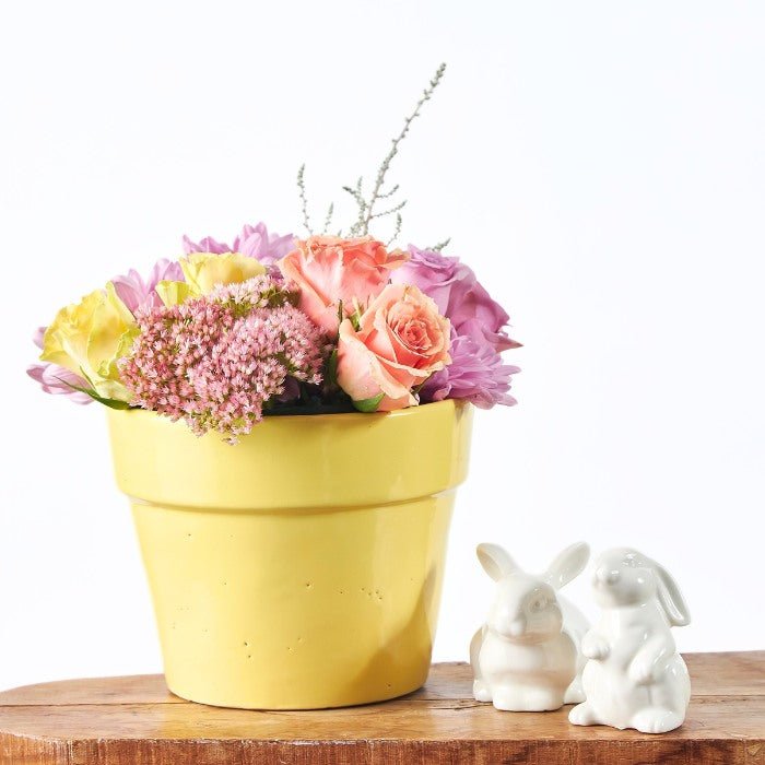 The Garden of Golden Joy - Fabulous Flowers & Gifts close-up of pastel floral pot with soft petals and ceramic Easter bunnies.