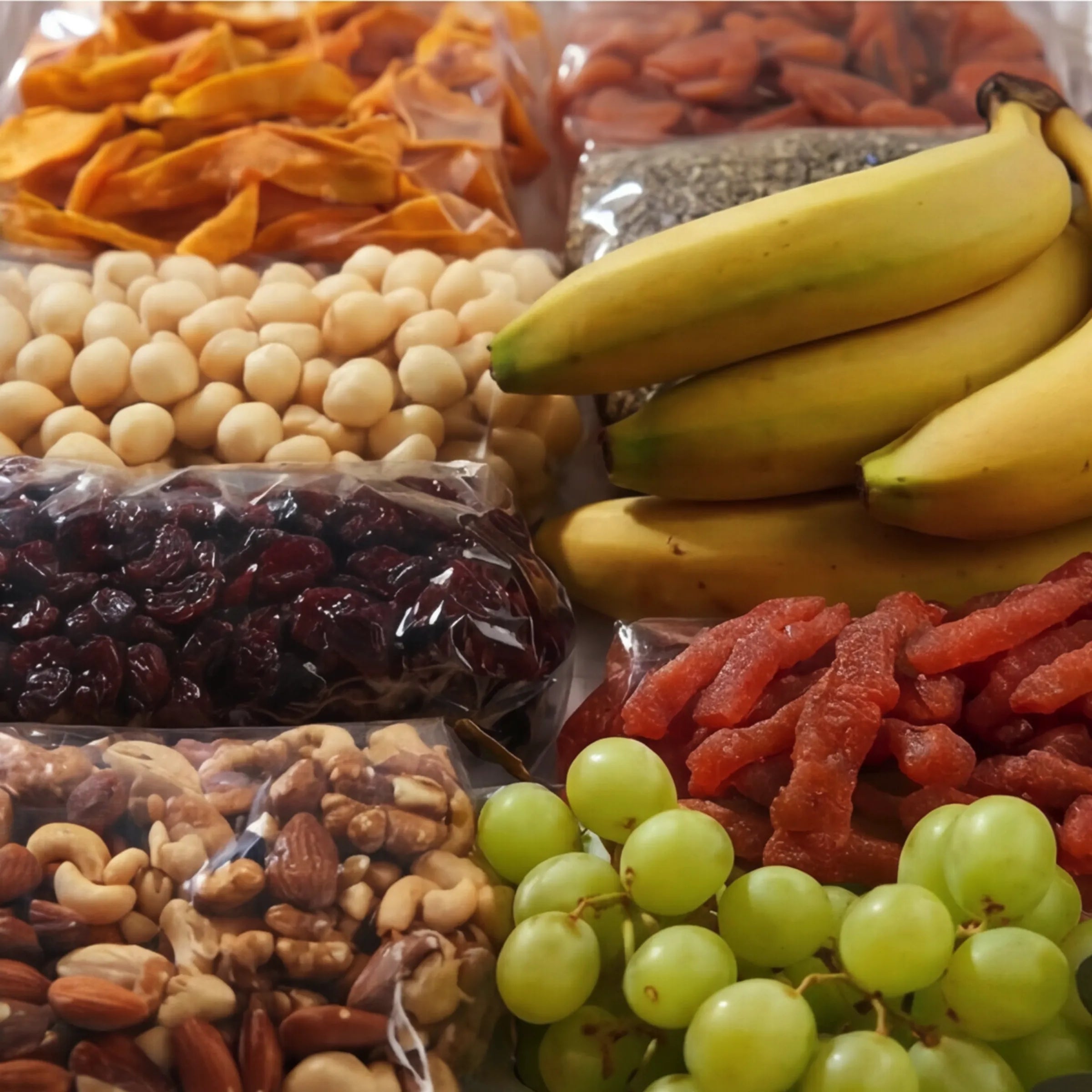 Close-up of the premium dried fruit, nuts and seeds inside The Healthy Collection by Fabulous Flowers South Africa, dried mango, apricots, meeboos, cranberries, chia seeds, macadamia nuts and mixed nuts with fresh bananas and green grapes, the savoury-leaning healthy gift box for Cape Town same-day delivery