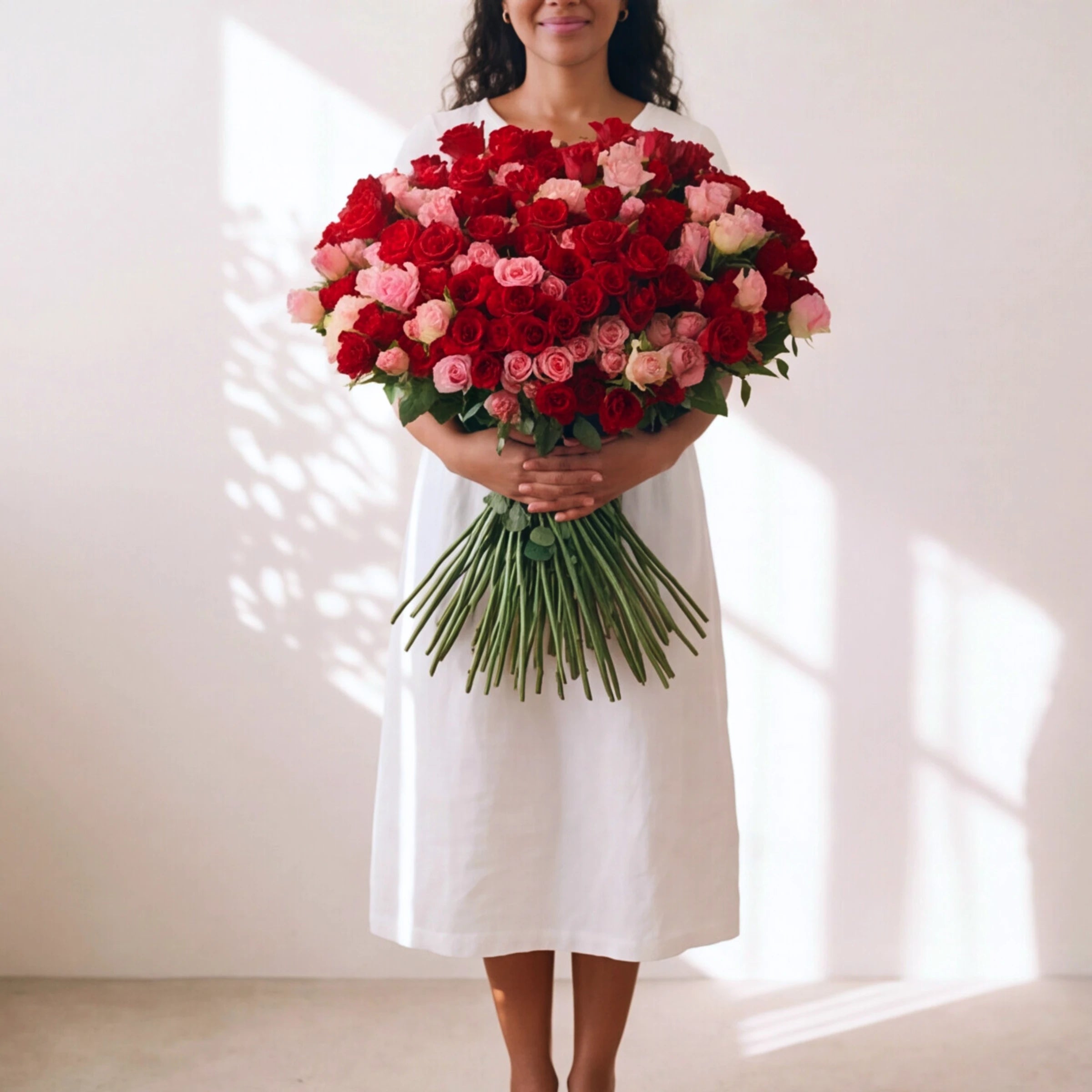 Woman holding the 250-rose Language of Love bouquet, long stems visible, hand-tied by our Cape Town florists