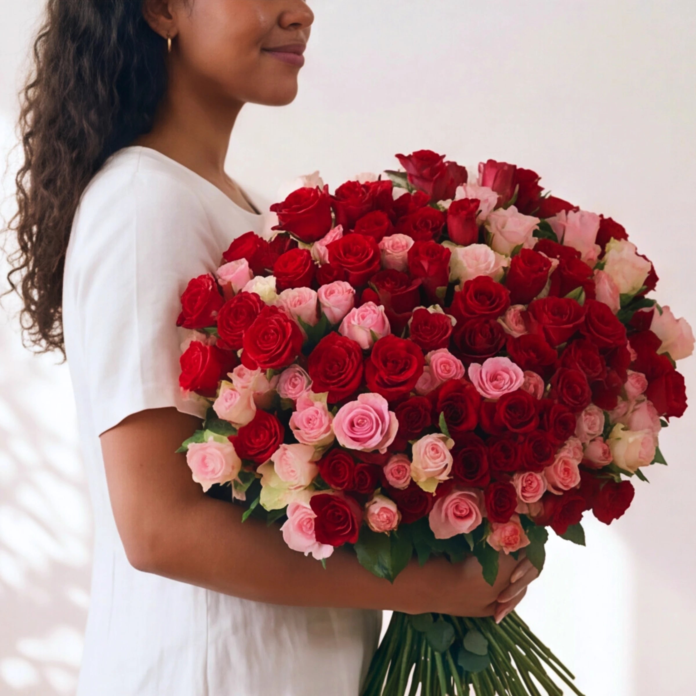 Side view of the 250-rose Language of Love rose bouquet carried on the arm, red and pink roses