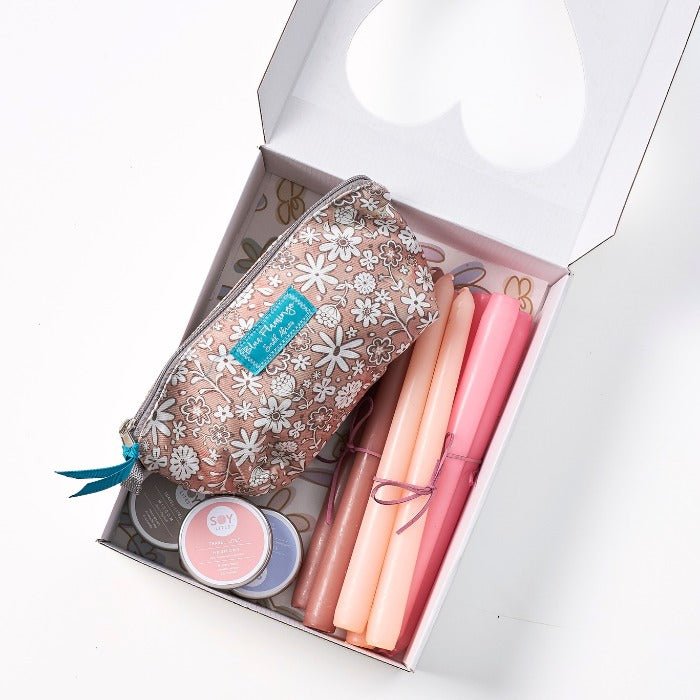 The Light She Gave - Fabulous Flowers & Gifts top-down view of pink candle gift box with daisy print pouch and soy wax tins.