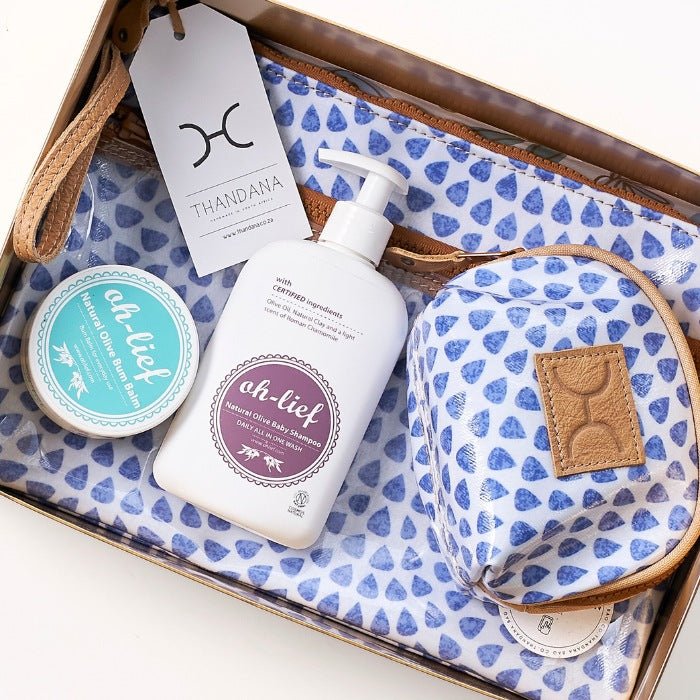 Their Gentle Welcome - Fabulous Flowers & Gifts close-up of blue baby gift set with Ah-Lief products and Thandana pouch.