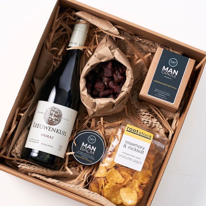 Carefully curated Yours Truly Hamper For Him with wine, gourmet snacks, and men's grooming essentials in a wooden box.