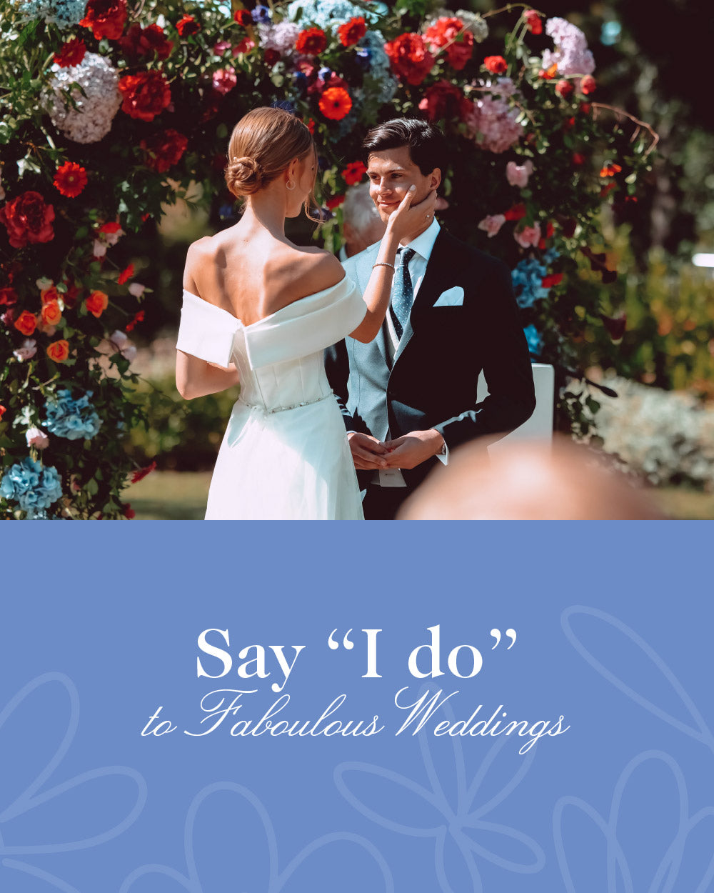 Bride in an off-shoulder white dress tenderly touching groom's face, standing under a colourful flower arch with text 'Say "I do" to Fabulous Weddings.' Weddings at Fabulous Flowers and Gifts.
