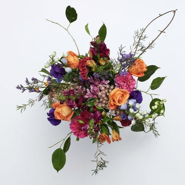 Glass jar vase arrangement with vibrant cheerful colours, seasonal dahlias, snapdragons, roses and alstroemeria 