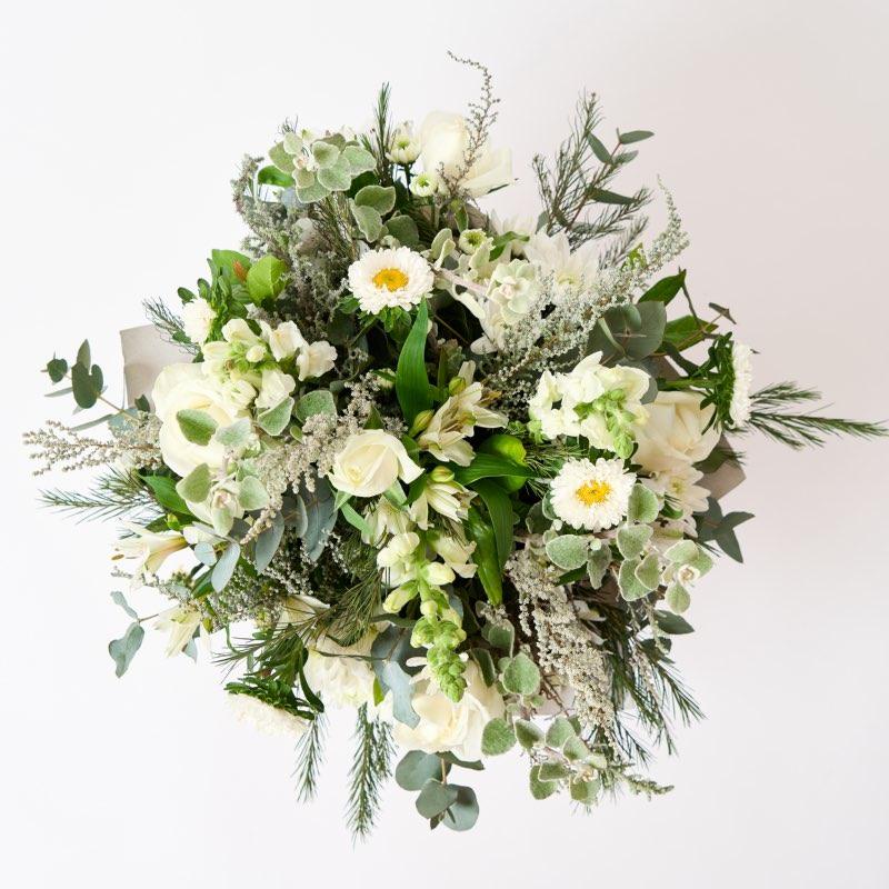 Tranquillity flower arrangement includes White roses, white Asters, Alstromeria, Snapdragons and Greenery wrapped in gold paper with a blue ribbon delivered by Fabulous Flowers and Gifts to the people you love in Cape Town. 