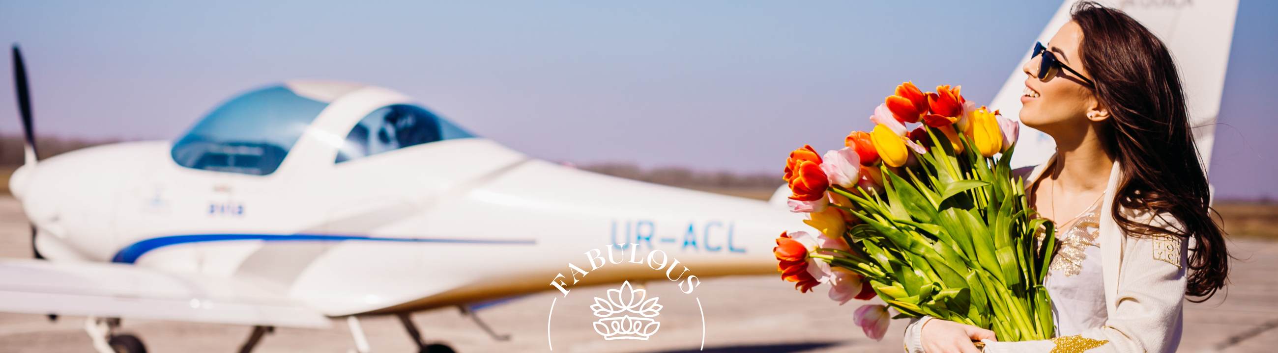 Are Flowers Allowed on a Plane? Woman holding bright tulip bouquet on runway beside small aircraft, travel flower guide.