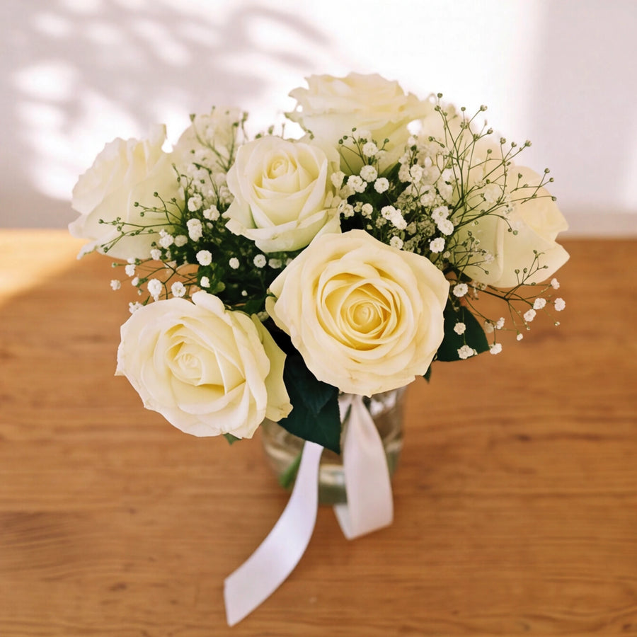 Overhead view of white roses and baby's breath in the Angel White glass jar arrangement by Fabulous Flowers