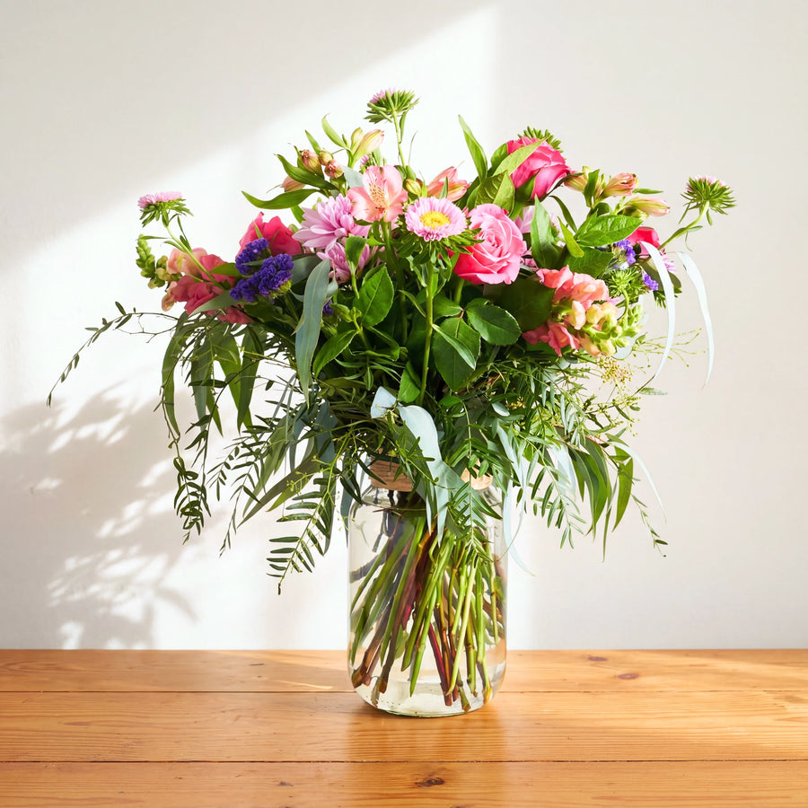 Beauty in a Bottle: pink roses, asters, alstroemeria and purple statice with eucalyptus in a glass jar