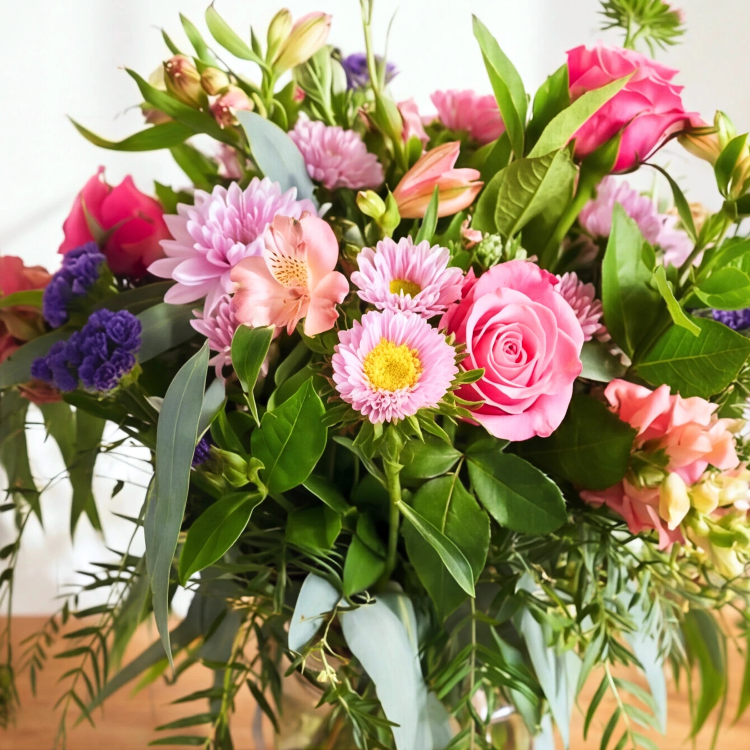 Close-up of a pink rose, lilac chrysanthemum and peach alstroemeria in the Beauty in a Bottle arrangement