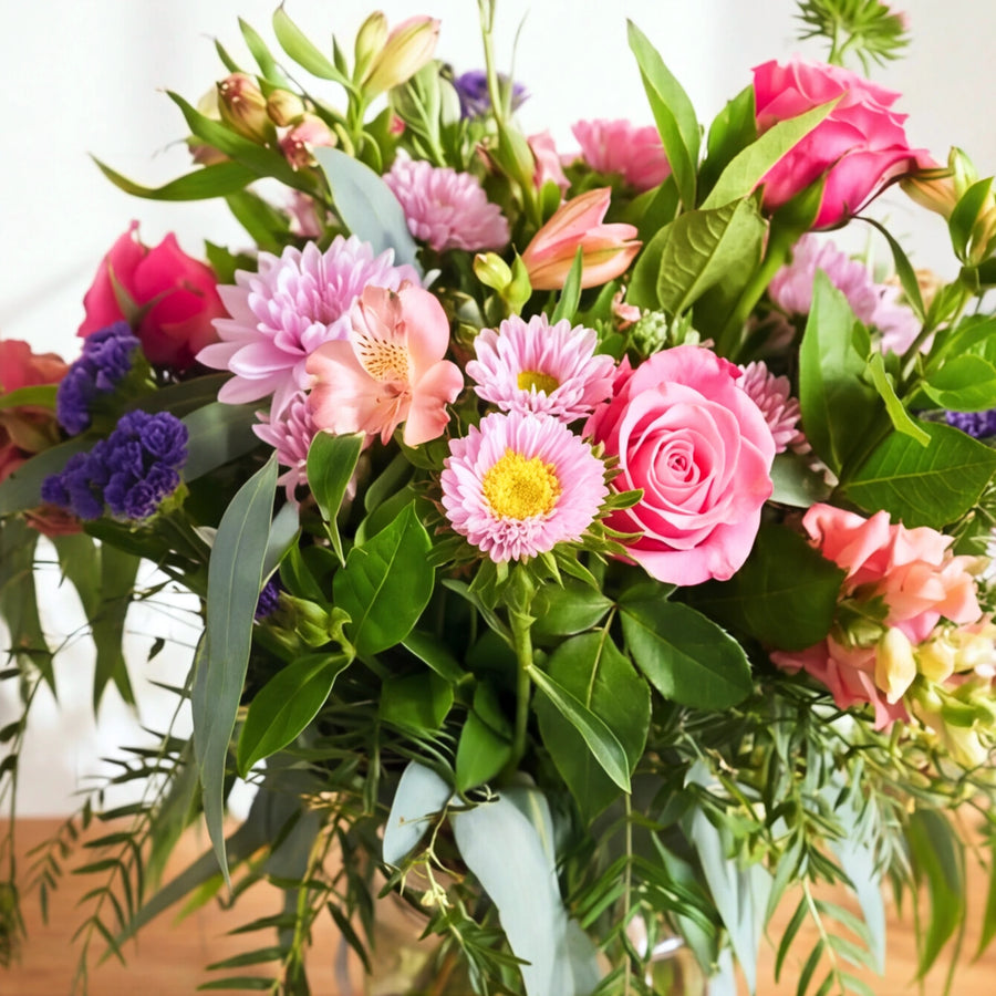 Close-up of a pink rose, lilac chrysanthemum and peach alstroemeria in the Beauty in a Bottle arrangement