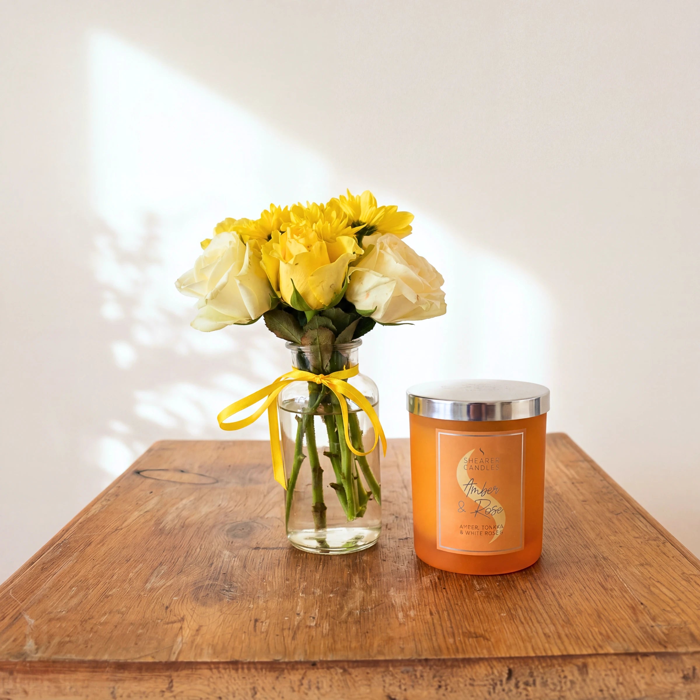 Bloom & Glow flowers and candle gift set: a yellow and cream rose posy with a Shearer Amber & Rose candle